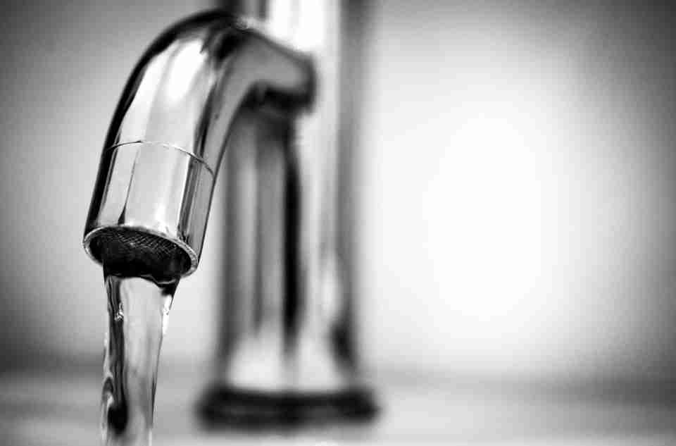 Water flowing through a faucet turned on